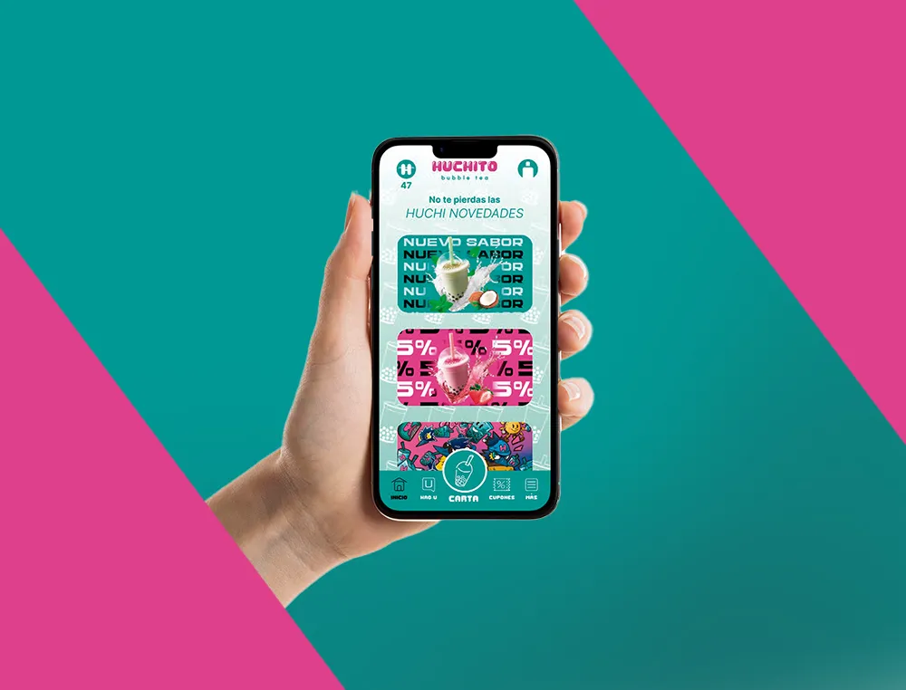 Una mano sostiene un móvil con las novedades de Huchito App